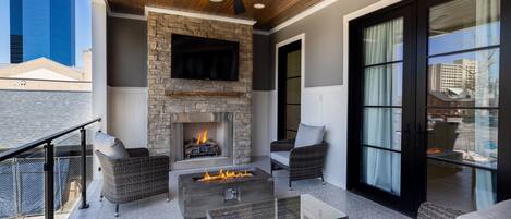 Outdoor patio with built in grill, fire pit, and outdoor TV