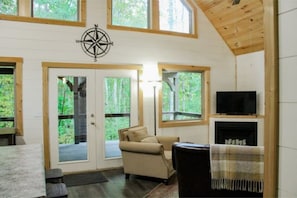 The peaceful living room and view of deck and forest