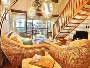 Modern, Hawai'ian-style living area with lanai, stairs to the loft, and TV.