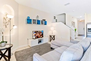 Welcoming Living area of the townhouse in Davenport Florida - Elegantly decorated space with a neutral color palette for a timeless appeal - Well-chosen lighting fixtures adding both functionality and charm - Comfy sofas and Smart TV