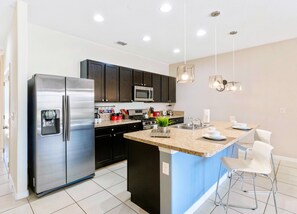 Lofty kitchen of the townhouse in Davenport Florida - Functional layout designed for efficient meal preparation - Plenty storage space for organized and clutter-free counters - Breakfast bar and high chairs