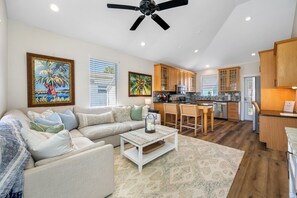 Open-concept space featuring a plush sectional, island seating, and a fully equipped kitchen.