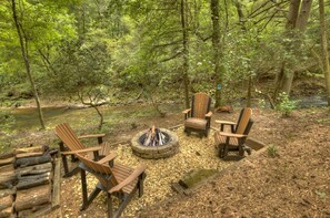 This amazing water front cabin rental has a firepit right on the creek