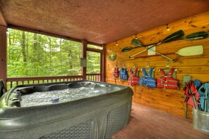 Relax in the hot tub on the screened porch overlooking the creek and lake below