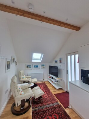 Living area. Plenty of light from the large velux windows and door to terrace.