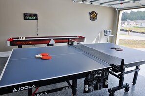 Cute little game room in the garage with ping-pong table, air hockey, and darts