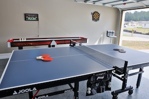 Cute little game room in the garage with ping-pong table, air hockey, and darts