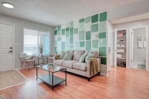 The painted walls in varying shades of green create a refreshing and tranquil atmosphere, complemented by lush indoor plants that bring nature indoors.