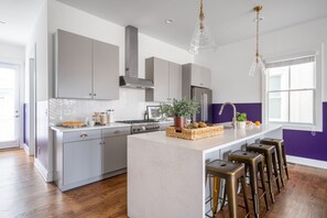 Kitchen features an island with a breakfast bar and modern appliances.