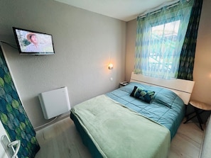 Chambre avec lit 2 personnes et télévision.