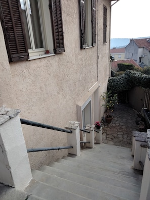 Accès à la maison depuis la rue par escalier (porte à gauche sur la photo)