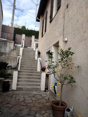 Accès à la maison depuis la rue par escalier (porte à droite sur la photo)