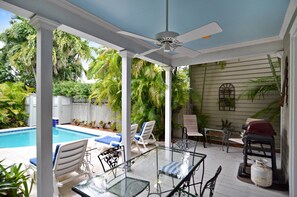 Backyard oasis features a pool and loungers.