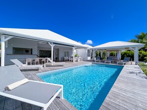 Tropical paradise: enchanting corner view of the terrace, sparkling pool, shaded patio and façade of the colonial-style villa