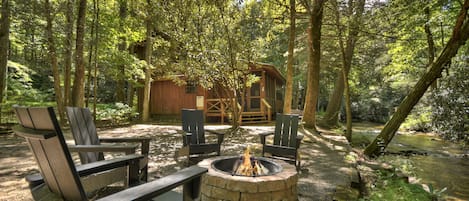 Gather around the firepit at this Incredible creek front cabin rental in Ellijay, GA