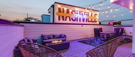 Instagrammable Rooftop Experience: Capture the essence of Nashville on our rooftop deck, featuring a neon light mural wall that reads "OPEN LATE Nashville." With outdoor dining, lounge seating, a fire pit, and downtown views, it's an Instagrammable spot that reflects the city's vibrant nightlife.