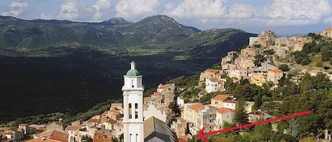 Corbara et la maison près de l'église. Au loin Calvi