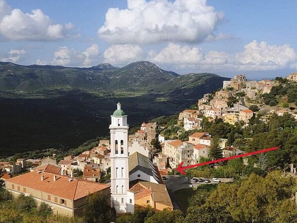 Corbara et la maison près de l'église. Au loin Calvi