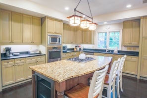 The renovated kitchen features a center island, granite counters, stainless steel appliances and top of the line cabinetry.
