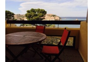 Terrasse équipée d'une table et 4 chaises avec éclairage extérieur.