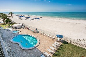 View of pool deck and beach from private balcony