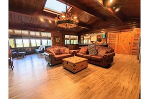 Separate family and living room with beautiful antler chandelier & skylights.