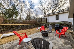 Large backyard equipped with a fire pit, grill, and plenty of room for activities.