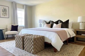 The second floor master suite is furnished with a king bed, comfy chair, and plush linen.  A full bathroom is only steps away, accessible directly through this bedroom's walk-in closet.  Large, inviting, and expertly designed - make it yours!