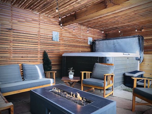 Unwind in our backyard haven, complete with a soothing hot tub, cozy firepit, and inviting seating area.