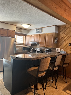 kitchen has breakfast bar with seating for three