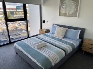 Master bedroom with floor to ceiling windows looking out to the mountains.