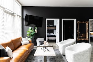 Comfortable living room with lots of natural light! Smart TV with all the apps you could want. Unique wallpaper throughout the condo + a full length mirror for getting ready for a fun night out.