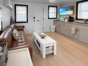 Cozy living room with leather sofa and pop-up coffee table to use as desk