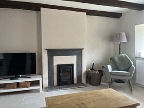 Sitting room with original  beams and wood-burning stove