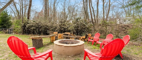 Wood burning Fire Pit with Chairs and Benches near Picnic Table & Creek in back