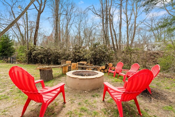 Wood burning Fire Pit with Chairs and Benches near Picnic Table & Creek in back