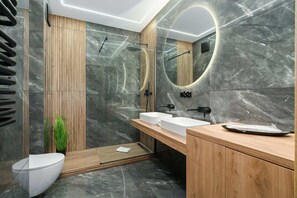 The bathroom's contemporary design includes fresh towels and a hairdryer.