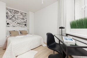 The cosy bedroom features a luxurious double bed and desk for remote work.