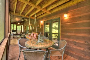 Screened porch with plenty of seating at the this lovely North Georgia Cabin Rental