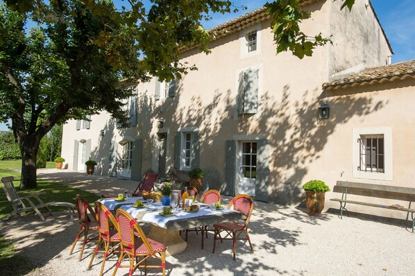 Le Mas avec sa terrasse ombragée par les majestueux platanes