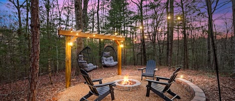 Captivating outdoor fire pit nestled amidst a natural landscape radiating a cozy and inviting warmth.  