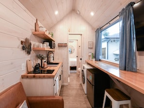 Here is the view of the kitchen / living room with the fridge, washer dryer, and on to the bedroom through the bathroom.