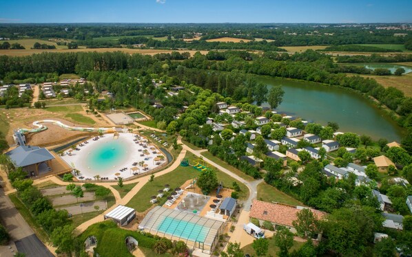 An aerial view of a luxurious pool and lake setting.