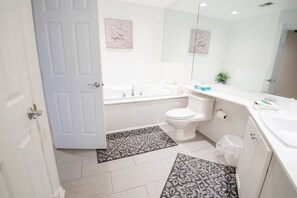 A perfectly sized bathroom with a soaker tub after a long day at the beach!