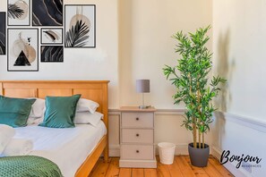 Second bedroom with a king size bed, bedside drawer and greenery