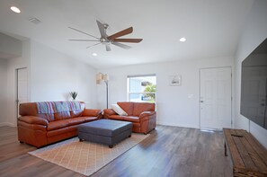 Spacious living area with vaulted ceiling and 85" smart TV.