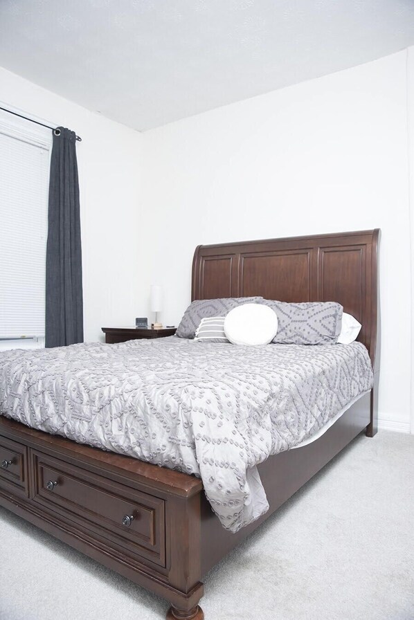 Bedroom with solid cherry queen size bed, 7 drawer dresser, and mirror.