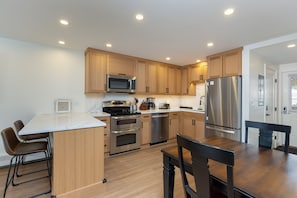 The updated kitchen offers quartz countertops, stainless steel appliances, and a breakfast bar that seats two.