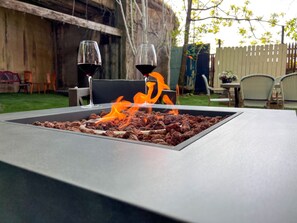 Relax by the fire and enjoy a glass of wine in the secluded backyard