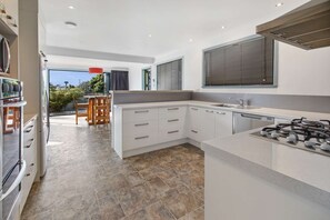 Fully kitted, modern kitchen with gas hob, microwave, and dishwasher.